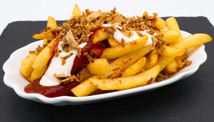 Spezialpommes vom Imbiss Fritz in Bielefeld: Knusprige Pommes, verfeinert mit Ketchup, Mayonnaise und frischen Zwiebeln – der perfekte Imbissklassiker.