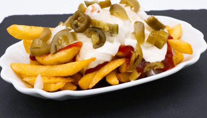 Teufelspommes vom Imbiss Fritz in Bielefeld: Knusprige Pommes mit würziger Sauce, Jalapeños und roten Zwiebeln – der scharfe Snack für echte Genießer.