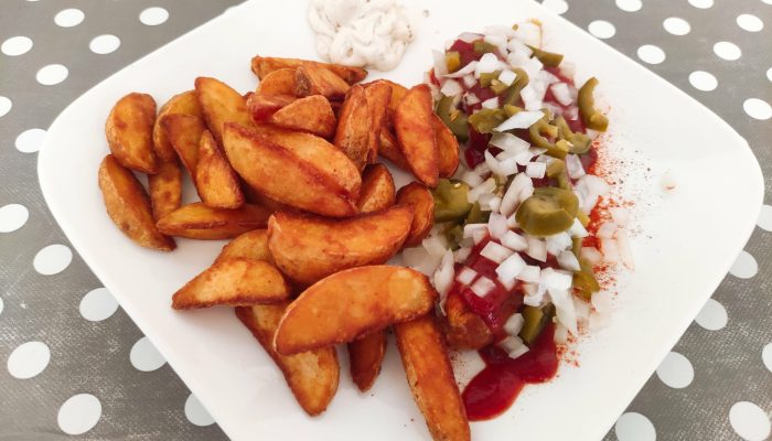 Teufelswurst mit Wedges vom Imbiss Fritz in Bielefeld: Feurige Bratwurst mit würziger Sauce, serviert mit knusprigen Wedges – der scharfe Genuss für Kenner.